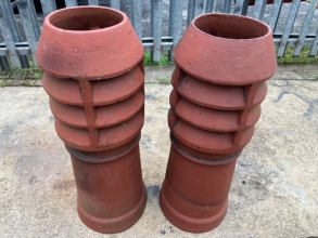 A pair of terracotta louvered chimney pots