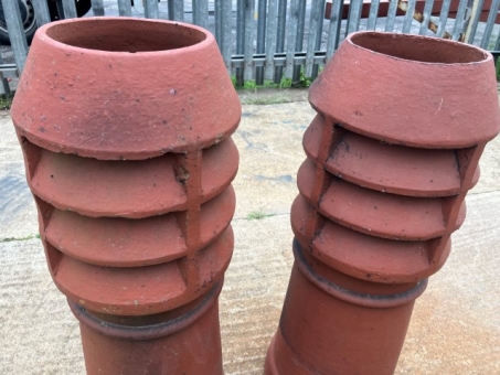 A pair of terracotta louvered chimney pots